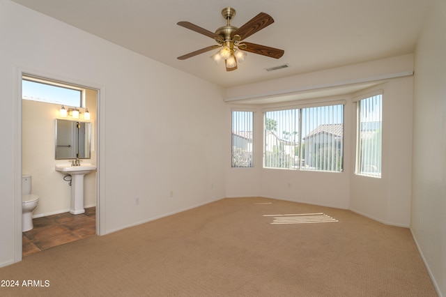 interior space featuring carpet flooring, ceiling fan, and ensuite bathroom