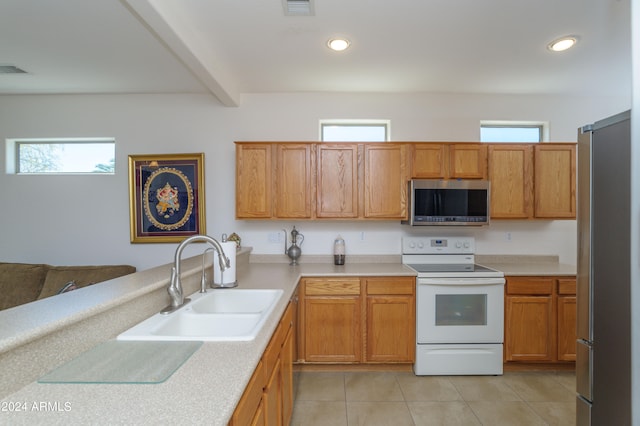 kitchen with stainless steel appliances, sink, and light tile floors