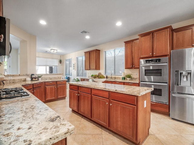 kitchen featuring sink, stainless steel appliances, a wealth of natural light, and a kitchen island