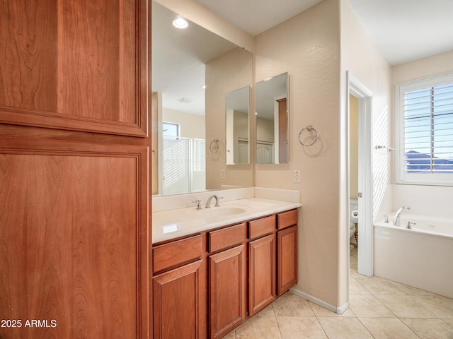 bathroom featuring toilet, tile patterned floors, a healthy amount of sunlight, and vanity