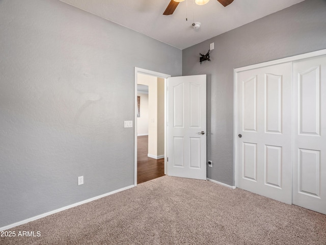 unfurnished bedroom featuring carpet flooring, ceiling fan, and a closet