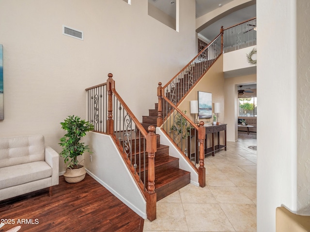 stairway with a high ceiling and ceiling fan