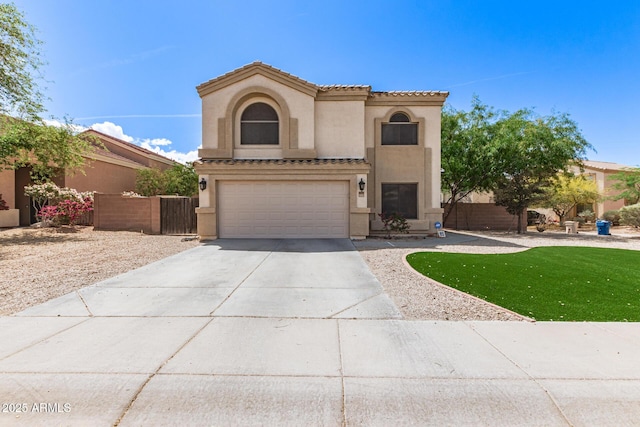 mediterranean / spanish home featuring fence, concrete driveway, a tile roof, an attached garage, and stucco siding