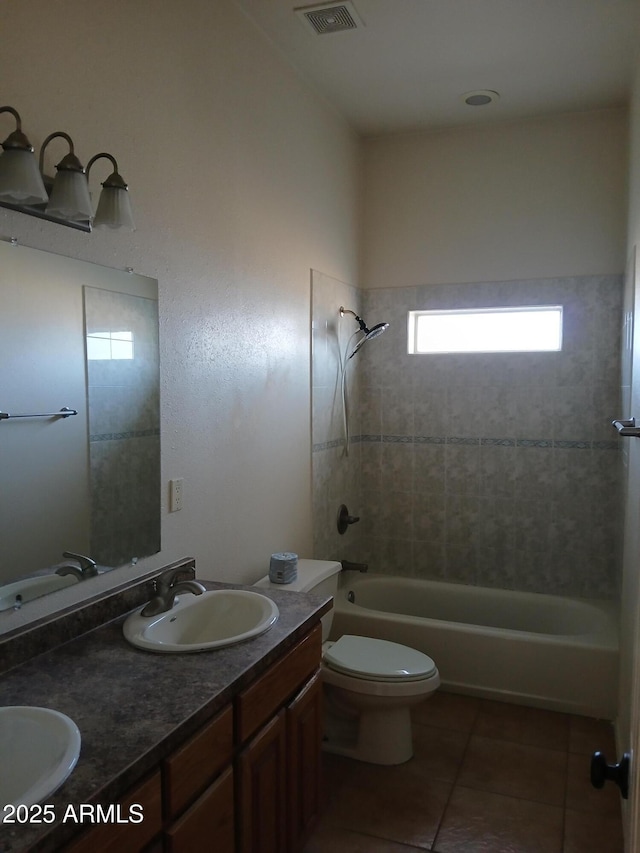 full bathroom featuring tiled shower / bath, vanity, toilet, and tile patterned flooring