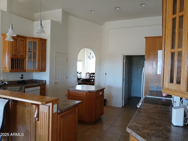 kitchen with a kitchen island, dishwasher, sink, hanging light fixtures, and tile patterned flooring