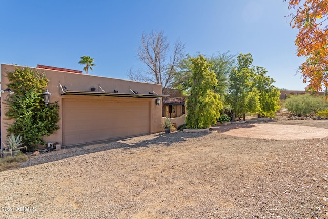 pueblo-style house featuring a garage