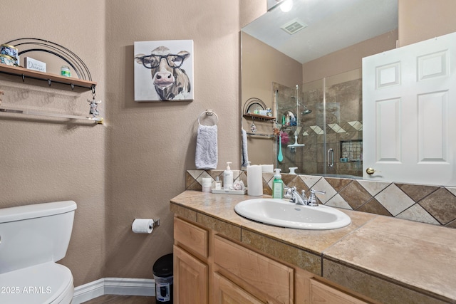 bathroom with decorative backsplash, vanity, an enclosed shower, and toilet