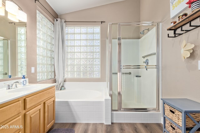 bathroom featuring vanity, hardwood / wood-style flooring, vaulted ceiling, and independent shower and bath