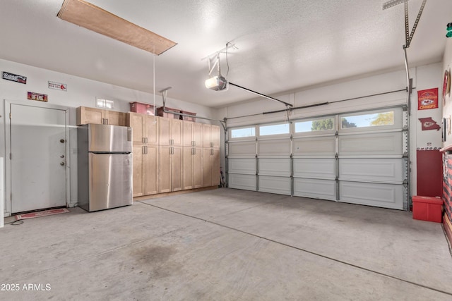 garage featuring stainless steel fridge and a garage door opener