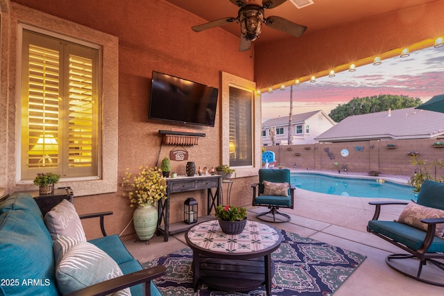 view of patio / terrace featuring ceiling fan and a fenced in pool