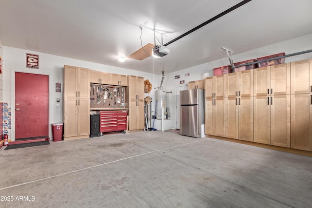 garage featuring a workshop area, stainless steel fridge, gas water heater, and a garage door opener