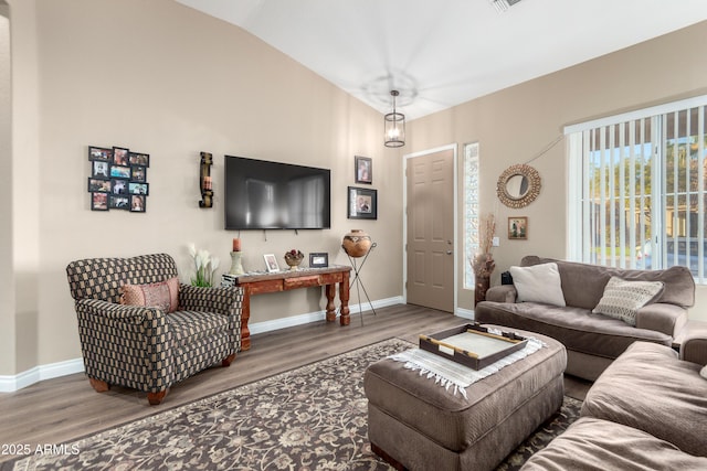 living room featuring lofted ceiling and hardwood / wood-style flooring