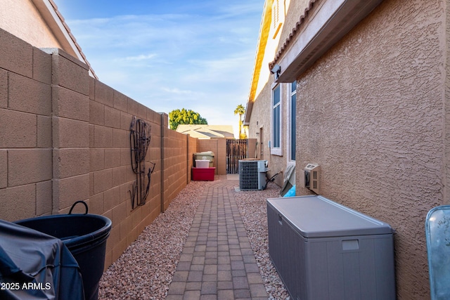 view of side of property featuring central air condition unit and a patio