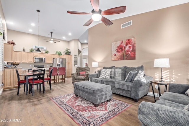 living room featuring high vaulted ceiling, light hardwood / wood-style flooring, and ceiling fan