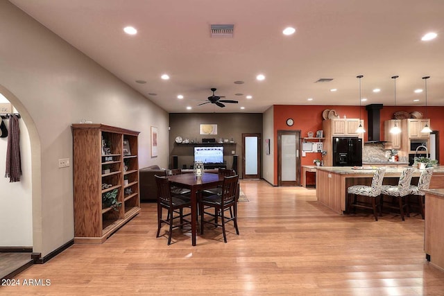 dining area with light hardwood / wood-style flooring and ceiling fan