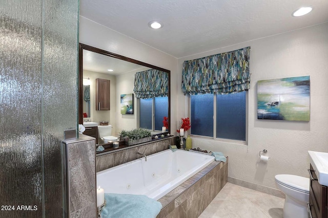 bathroom featuring toilet, tile floors, a relaxing tiled bath, and large vanity