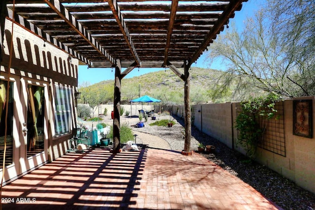 view of terrace with a pergola and a mountain view