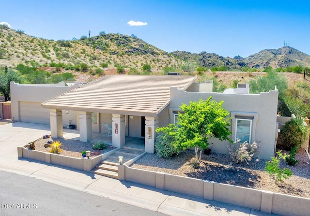 pueblo-style home featuring a mountain view and a garage