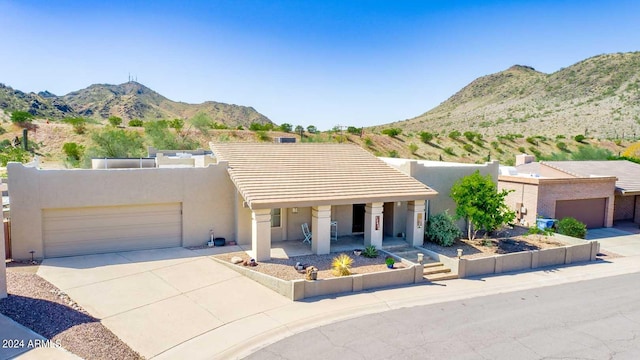 pueblo revival-style home with a mountain view and a garage