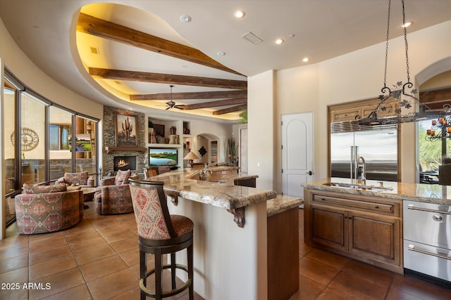 7731 E Soaring Eagle Way, Scottsdale, AZ 85266 - kitchen featuring stainless steel appliances, open floor plan, a fireplace, dark tile patterned floors, and ceiling fan