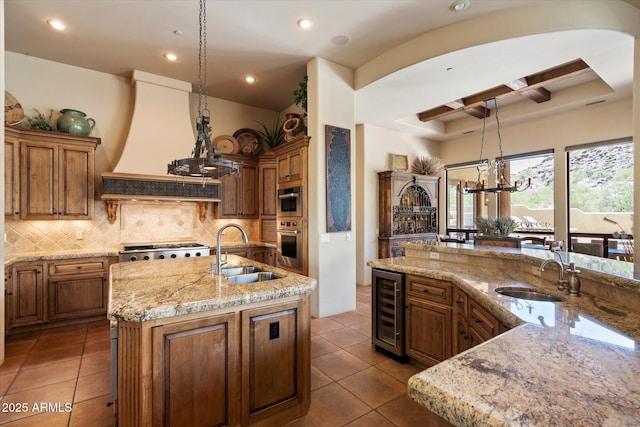 7731 E Soaring Eagle Way, Scottsdale, AZ 85266 - kitchen featuring beverage cooler, stainless steel oven, an island with sink, coffered ceiling, and recessed lighting