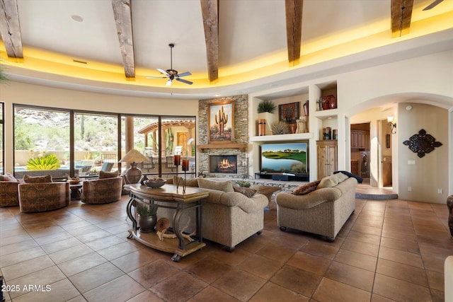 7731 E Soaring Eagle Way, Scottsdale, AZ 85266 - living area with a ceiling fan, a raised ceiling, arched walkways, built in shelves, and beam ceiling