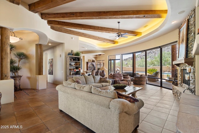 7731 E Soaring Eagle Way, Scottsdale, AZ 85266 - living room featuring arched walkways, tile patterned floors, beam ceiling, a towering ceiling, and ceiling fan