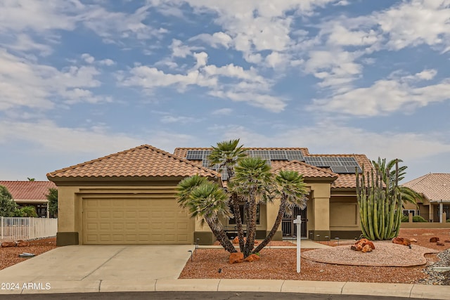 mediterranean / spanish-style house with solar panels and a garage