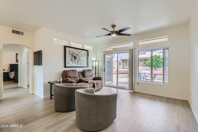 living room with ceiling fan and light hardwood / wood-style flooring