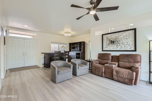 living room with ceiling fan and light hardwood / wood-style flooring