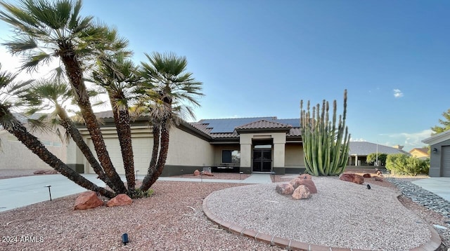 view of front of property featuring a garage and solar panels