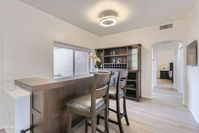 bar with light hardwood / wood-style floors