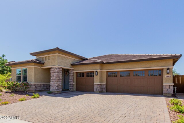 20603 W Alsap Rd, Buckeye, AZ 85396 - prairie-style home featuring stone siding, an attached garage, stucco siding, and decorative driveway