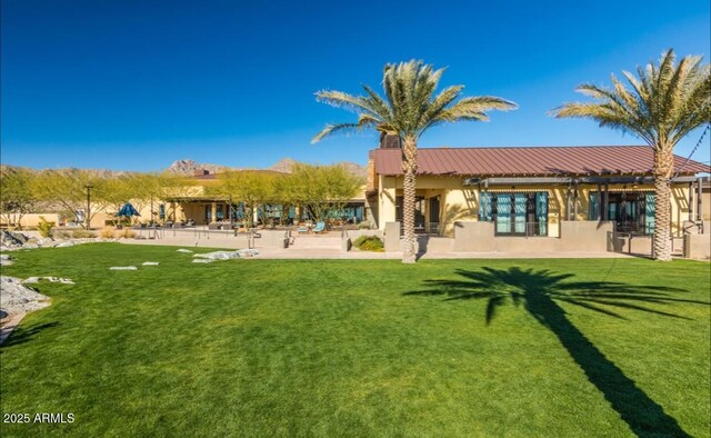 20603 W Alsap Rd, Buckeye, AZ 85396 - rear view of property featuring stucco siding, a yard, and metal roof