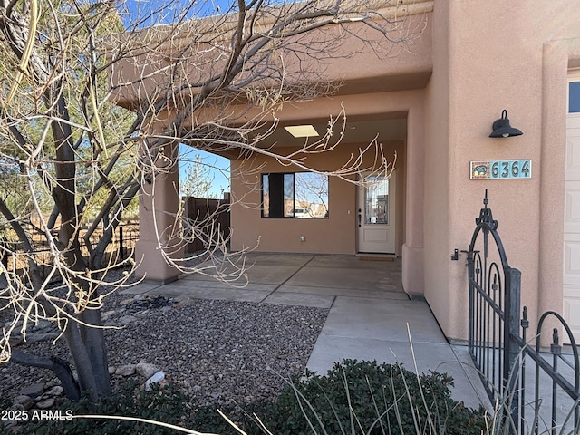 property entrance featuring a patio area and stucco siding