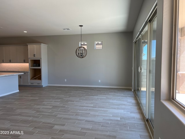 kitchen featuring white cabinets, pendant lighting, and light hardwood / wood-style floors