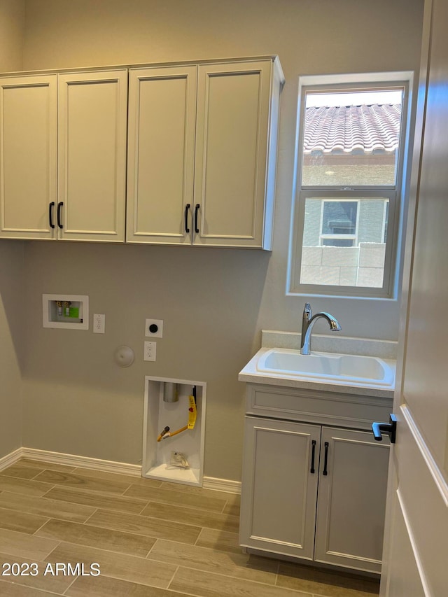 washroom with gas dryer hookup, hookup for an electric dryer, cabinets, washer hookup, and sink