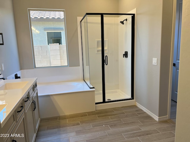 bathroom with vanity and shower with separate bathtub