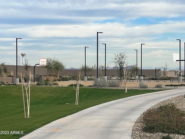 surrounding community featuring basketball court and a yard