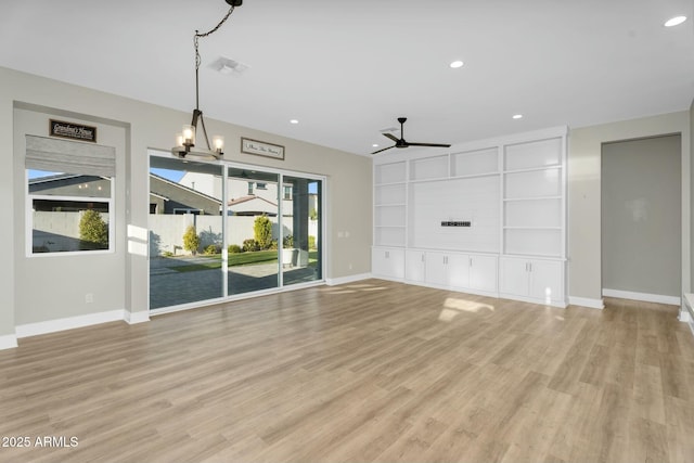 unfurnished living room featuring visible vents, ceiling fan with notable chandelier, light wood-type flooring, and baseboards