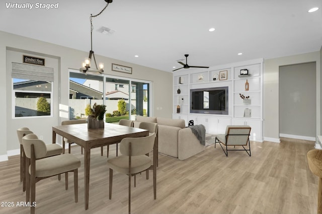 dining room with visible vents, light wood-style flooring, ceiling fan with notable chandelier, recessed lighting, and baseboards