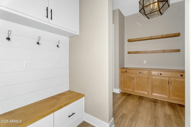 mudroom featuring light wood-style flooring and baseboards