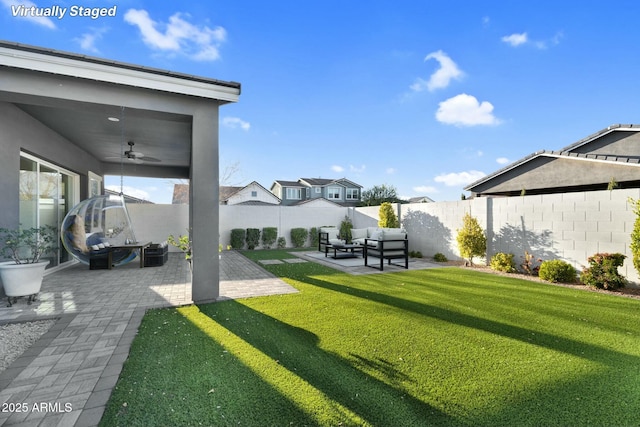 view of yard featuring outdoor lounge area, a patio, a fenced backyard, and ceiling fan