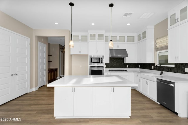 kitchen with visible vents, a sink, decorative backsplash, stainless steel appliances, and under cabinet range hood