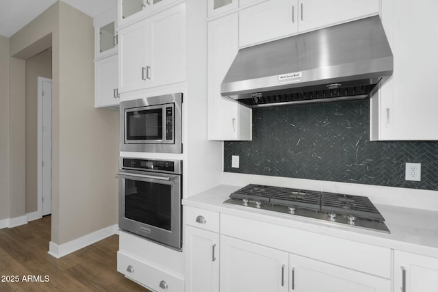 kitchen with under cabinet range hood, white cabinets, light countertops, and appliances with stainless steel finishes
