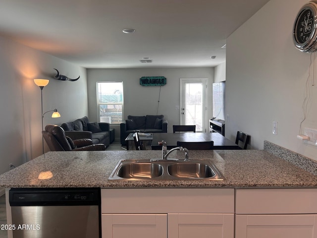 kitchen with dishwasher, plenty of natural light, a sink, and white cabinetry