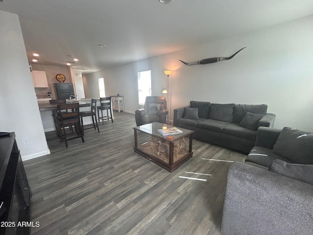 living room featuring recessed lighting, dark wood-style flooring, and baseboards