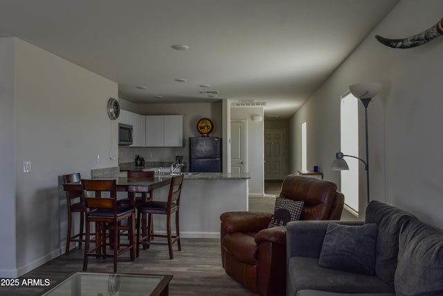 living room featuring dark wood-style floors and baseboards