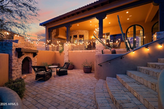 patio terrace at dusk with an outdoor stone fireplace