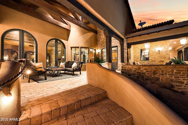 patio terrace at dusk featuring an outdoor living space